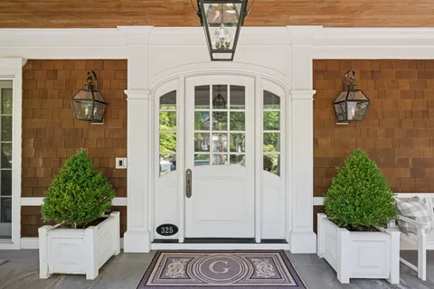 a living room with furniture a clock and a large window
