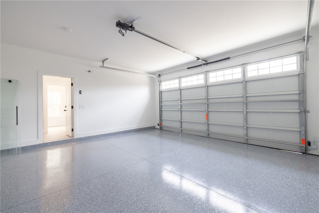 502 Point Road Westminster, SC 29693 - Photo 28 of 49 A spacious garage boasts a speckled epoxy floor and an automatic overhead door with transom windows.
