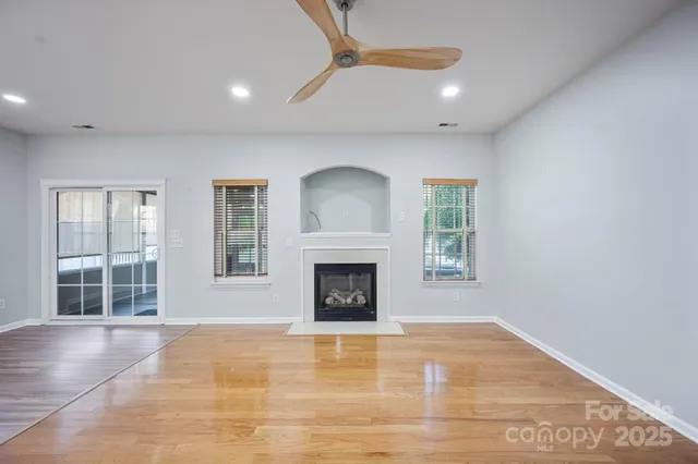 a view of an empty room with a window and fireplace
