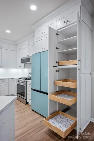 a kitchen with white cabinets and appliances