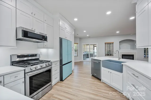 a kitchen with white cabinets and stainless steel appliances