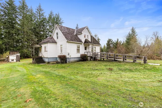 a view of a house with a big yard and large trees