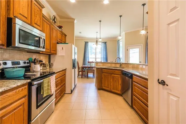 a large kitchen with stainless steel appliances granite countertop a stove a sink and a refrigerator