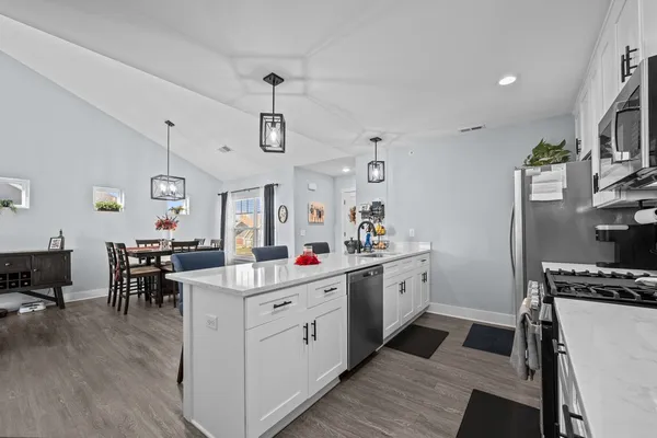 a kitchen that has a lot of cabinets a sink and appliances in it