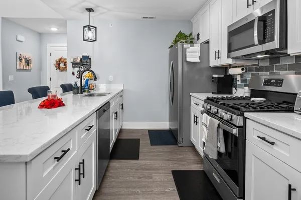 a kitchen with stainless steel appliances granite countertop a sink and a stove