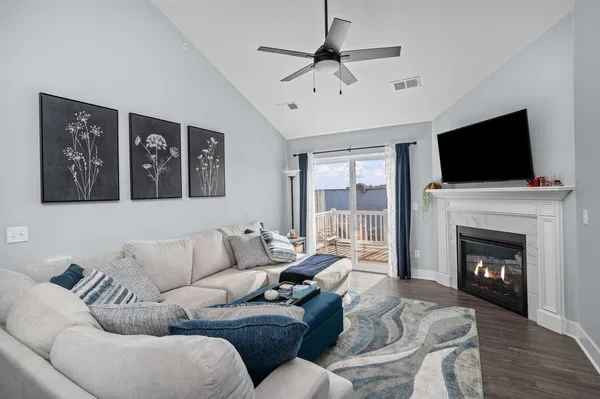 a living room with furniture a fireplace and a flat screen tv