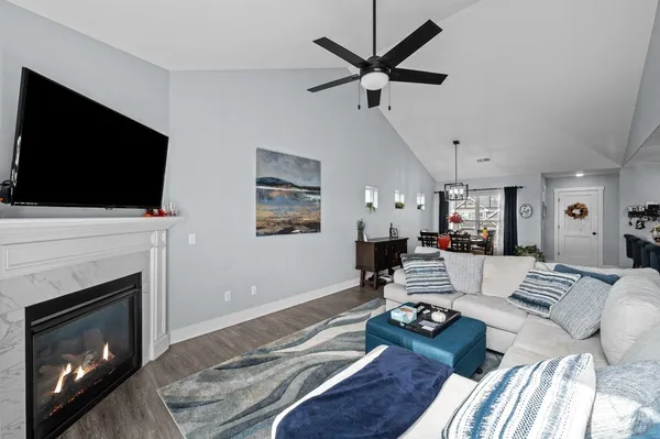 a living room with furniture a flat screen tv and a fireplace