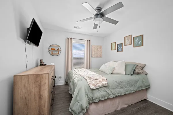 a living room with a bed furniture and a flat screen tv