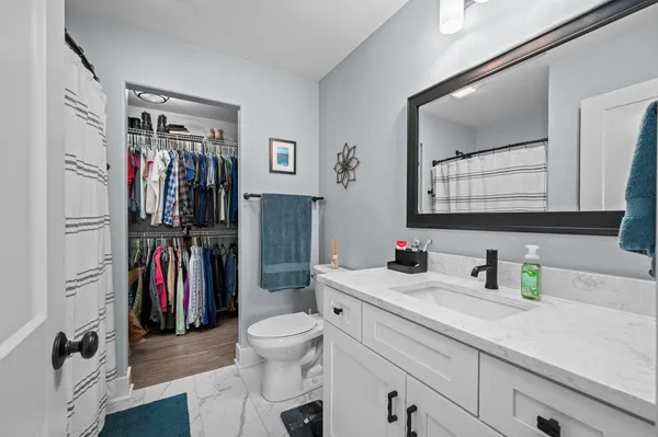 a bathroom with a sink a toilet and a mirror