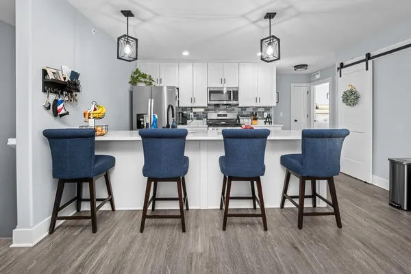 a view of a dining room with furniture a rug and wooden floor