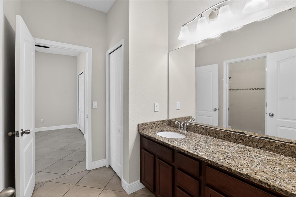 817 Dusty Pine Drive Ocoee, FL 34761 - Photo 12 of 16 a bathroom with a granite countertop sink and a mirror