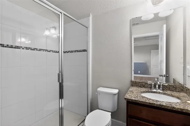 a bathroom with a granite countertop sink toilet and shower