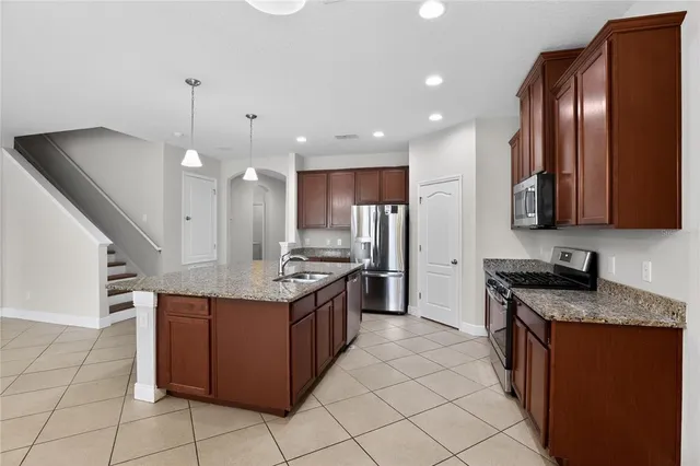 a large kitchen with stainless steel appliances granite countertop a stove and a sink