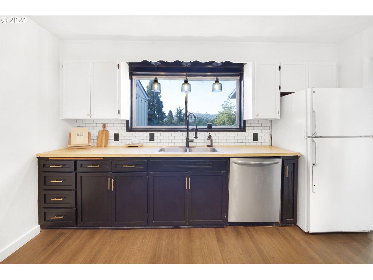6988 Bluebelle Way Springfield, OR 97478 - Photo 6 of 28 a kitchen with a sink cabinets and a large window