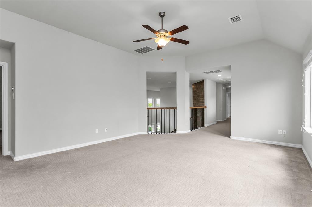 6333 Hall Road Frisco, TX 75034 - Photo 26 of 38 Spacious upper-level room featuring light gray carpeting, vaulted ceiling with a ceiling fan, and white trim