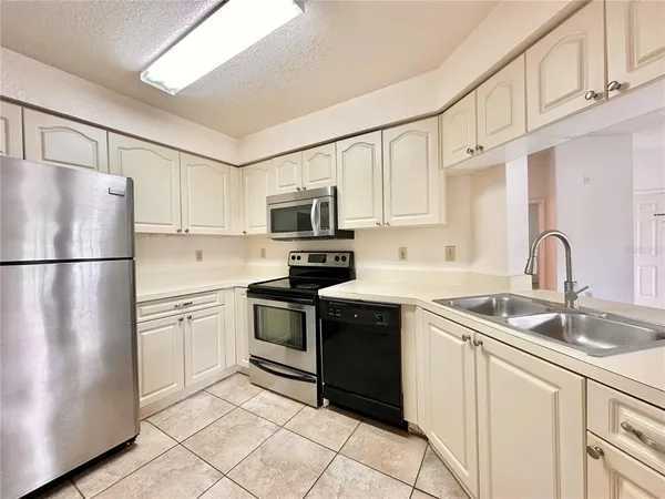 a kitchen with stainless steel appliances granite countertop a refrigerator sink and stove