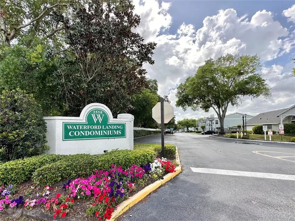 a view of a house with pool lawn chairs and a barbeque