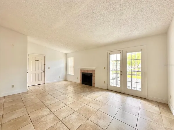 a view of an empty room with a fireplace and a window