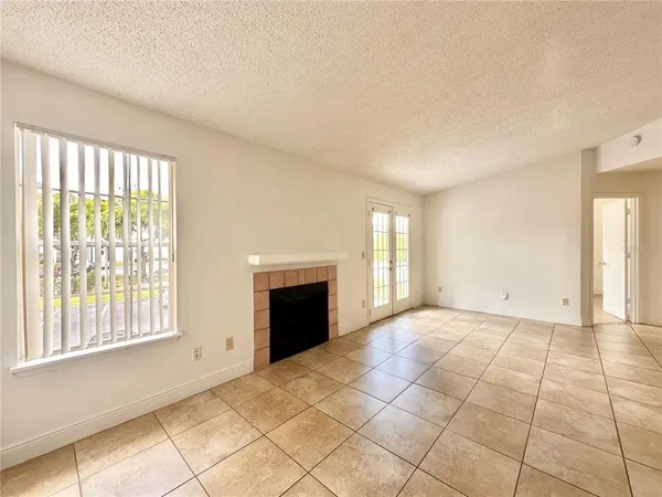 a view of an empty room with a fireplace and a window