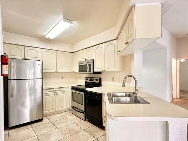 a kitchen with stainless steel appliances a refrigerator sink and cabinets