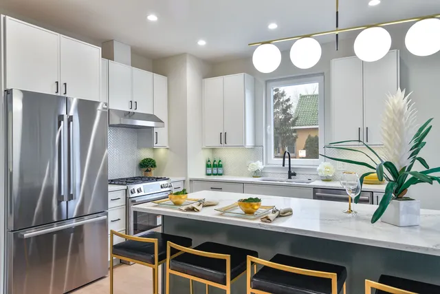 a kitchen with stainless steel appliances a refrigerator a sink a stove and cabinets