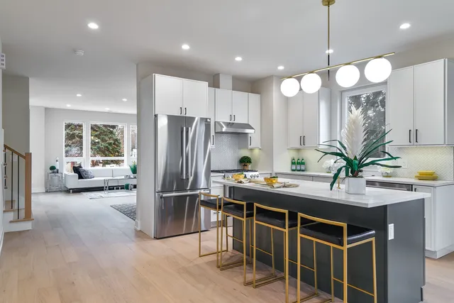 a kitchen with kitchen island a large counter top space appliances and a living room view