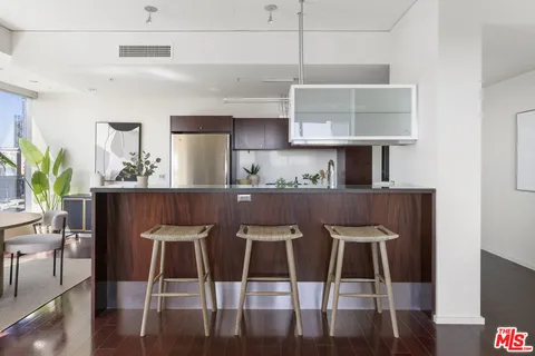 a kitchen with stainless steel appliances kitchen island granite countertop a table and chairs in it