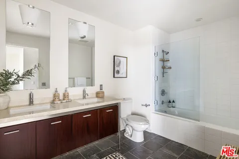 a bathroom with a double vanity sink toilet and shower