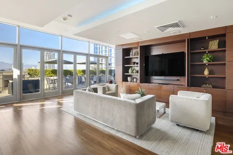 a living room with furniture wooden floor and a large window