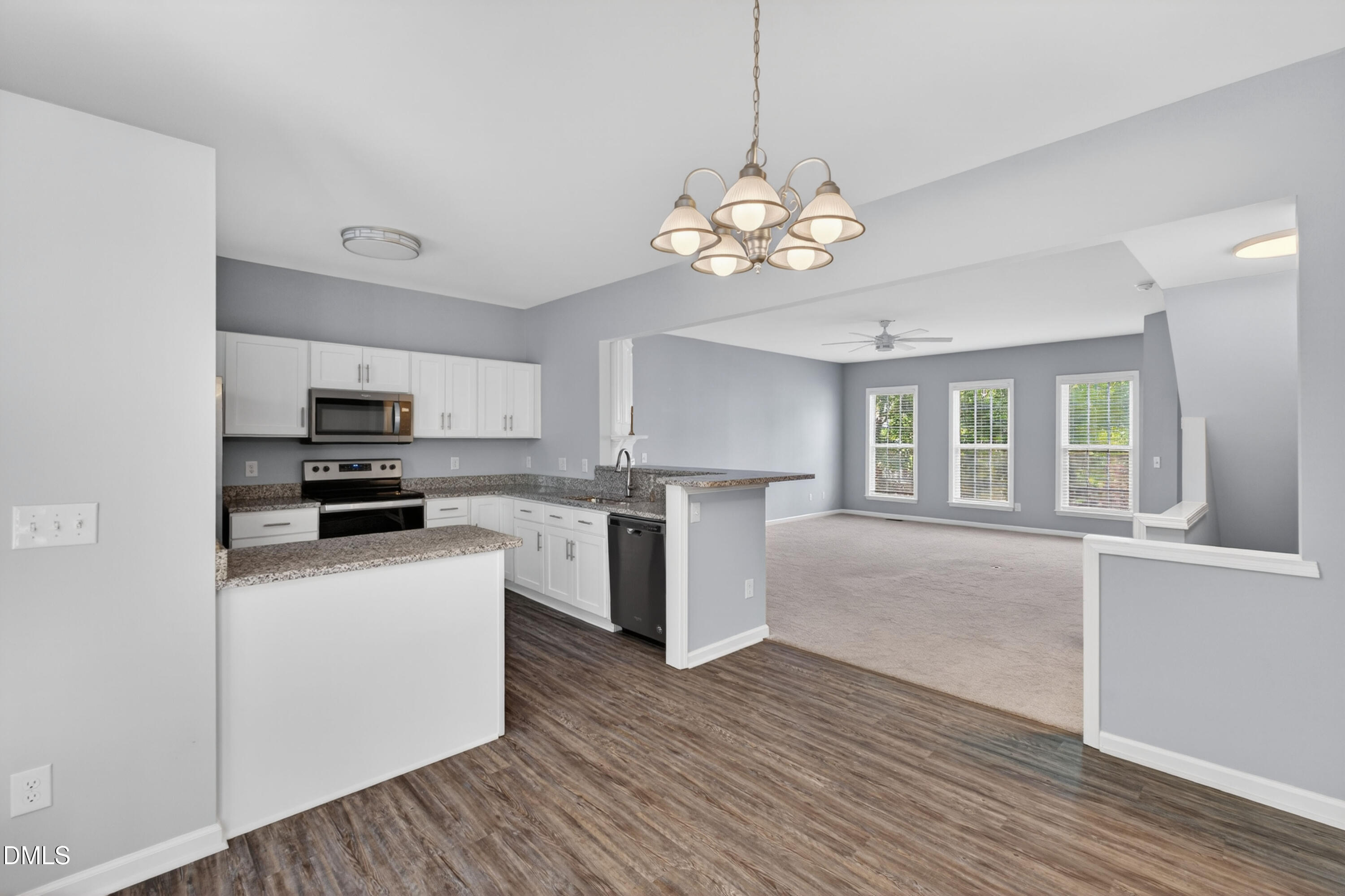 5421 Golden Arrow Lane Raleigh, NC 27613 - Photo 19 of 49 a kitchen with stainless steel appliances granite countertop a refrigerator a stove top oven a sink dishwasher and white cabinets with wooden floor