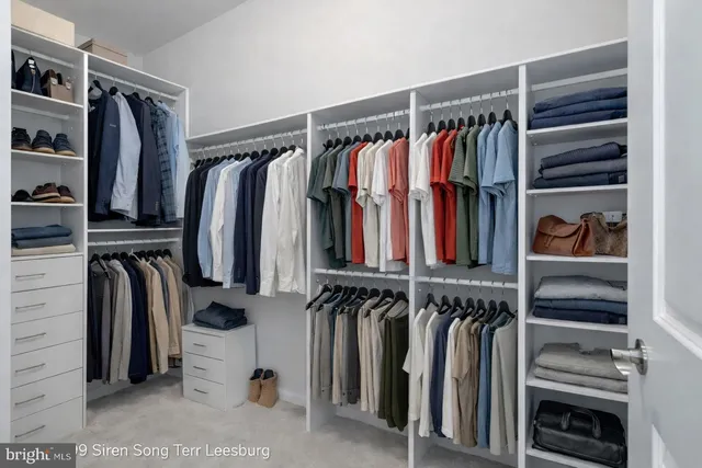 a view of walk in closet with clothes and shoes