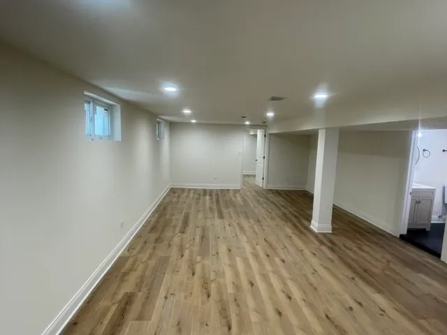 a view of an empty room with wooden floor and closet