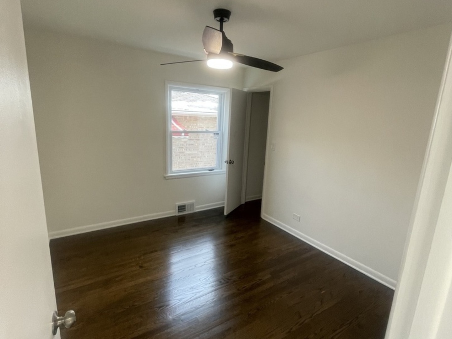 654 West 111th Street Chicago, IL 60628 - Photo 4 of 22 an empty room with wooden floor chandelier fan and windows