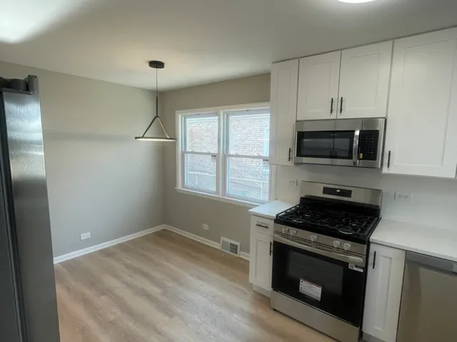 a kitchen with stainless steel appliances granite countertop a refrigerator and a stove