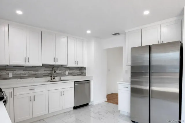 a kitchen with a refrigerator sink and cabinets