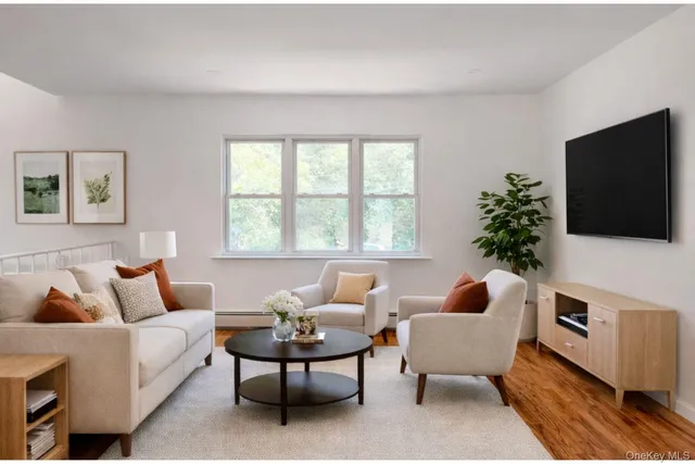 a living room with furniture a flat screen tv and a window