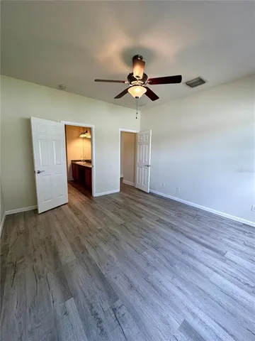 a view of room with hardwood floor ceiling fan and window