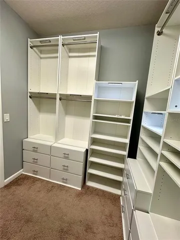 a view of walk in closet with empty racks