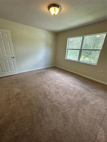 an empty room with windows and ceiling fan view