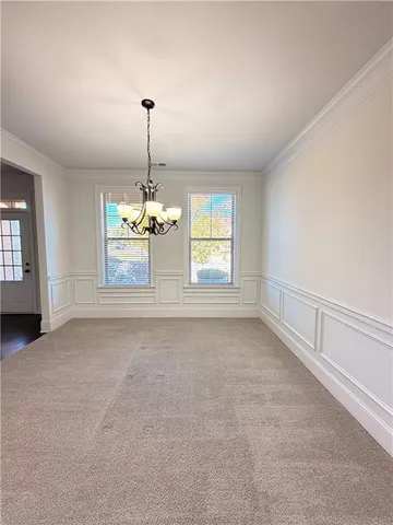 an empty room with chandelier and windows