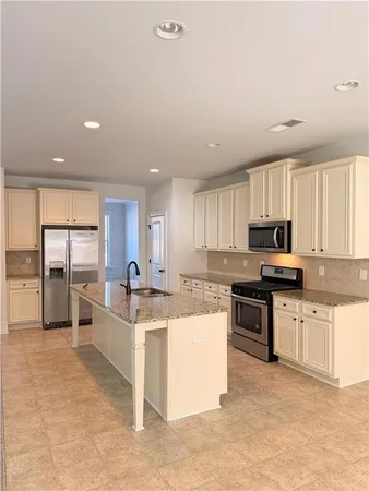 a kitchen with stainless steel appliances granite countertop a stove top oven a sink a counter top space and cabinets