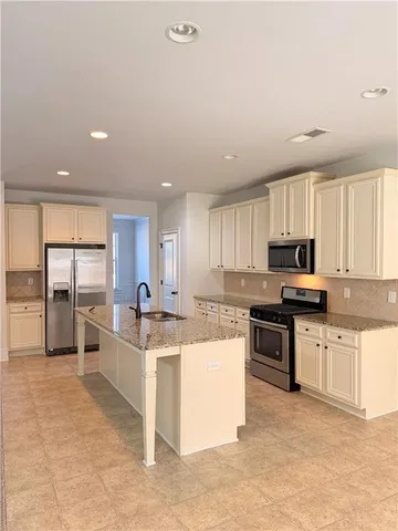 a kitchen with stainless steel appliances granite countertop a stove top oven a sink a counter top space and cabinets