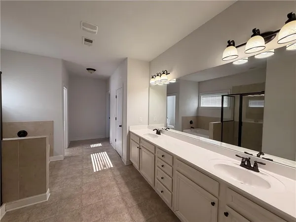 a large bathroom with a tub sink shower and mirror