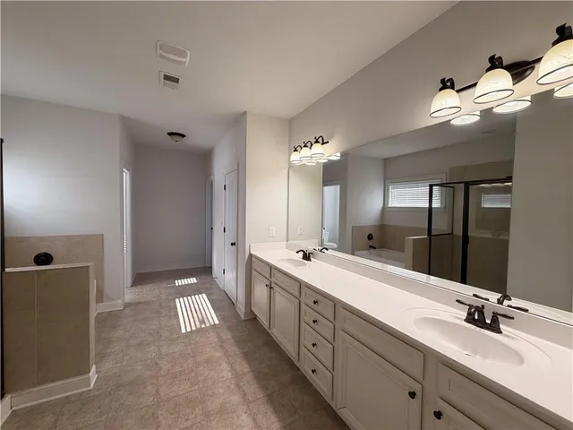 a large bathroom with a tub sink shower and mirror