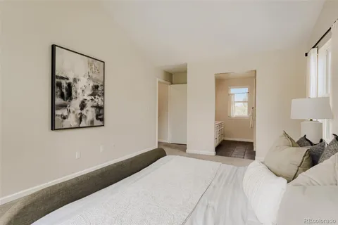 a bedroom with a bed and a painting on the wall