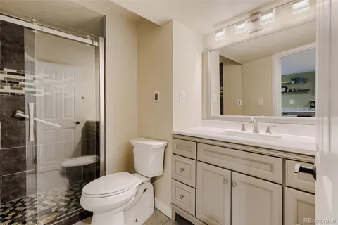 a bathroom with a toilet sink shower and mirror