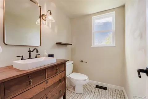 a bathroom with a sink a toilet and mirror