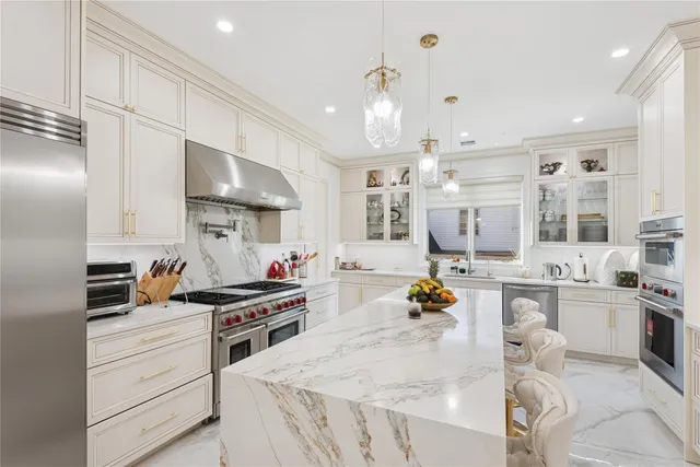 a kitchen with stainless steel appliances kitchen island granite countertop a sink stove and cabinets
