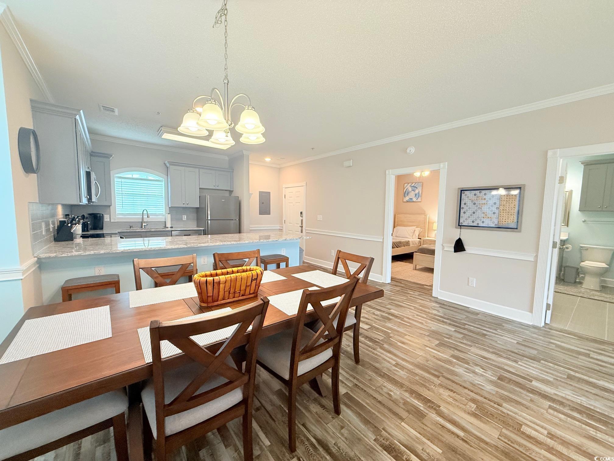 4860 Carnation Circle, Unit 17105 Myrtle Beach, SC 29577 - Photo 13 of 29 Dining room featuring light wood-type flooring, a chandelier, and ornamental molding