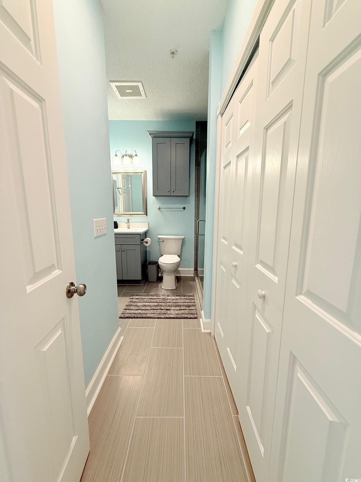 4860 Carnation Circle, Unit 17105 Myrtle Beach, SC 29577 - Photo 14 of 29 Full bath featuring vanity, a stall shower, a textured ceiling, and light tile patterned floors